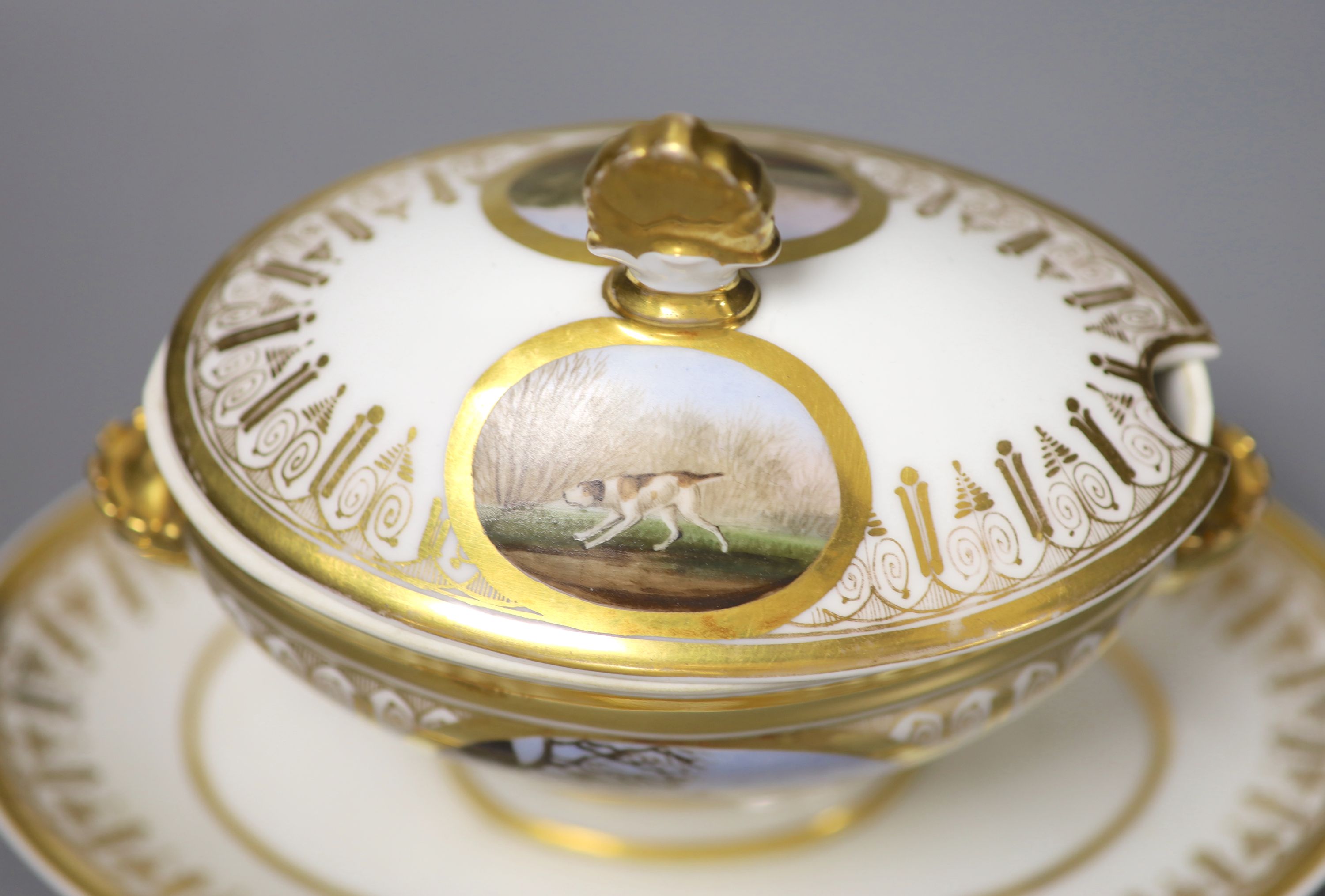 A Paris porcelain tureen and cover highly gilded and painted with four oval panels, two with dogs, one with a stag and one with two har